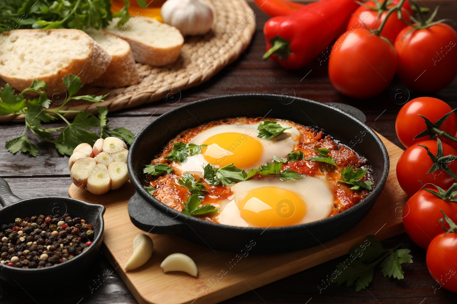 Photo of Delicious shakshuka in frying pan on wooden table