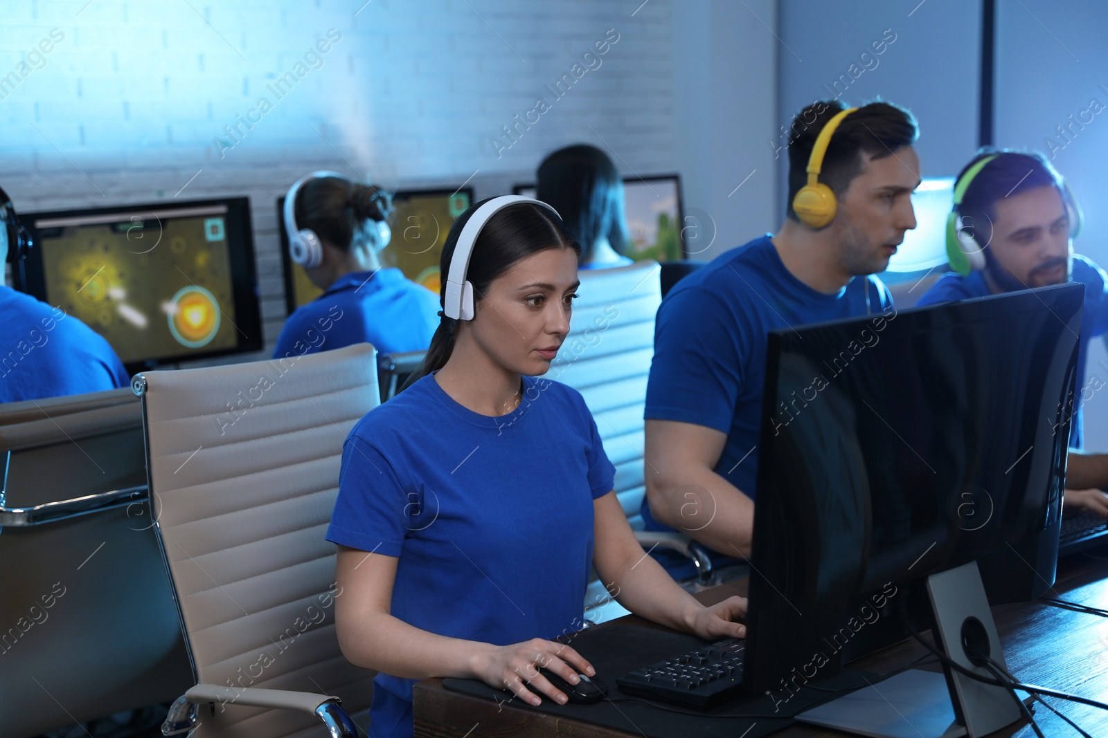 Photo of Young people playing video games on computers indoors. Esports tournament