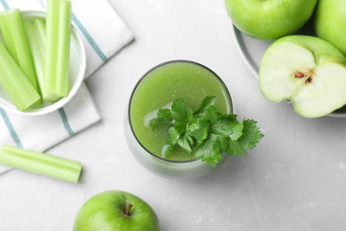 Photo of Flat lay composition with glass of fresh celery juice on light marble table