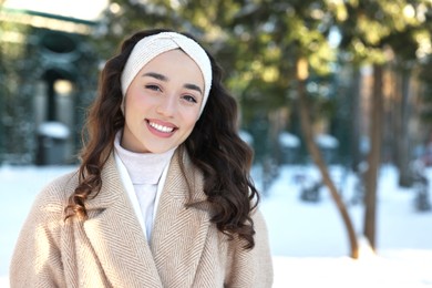 Photo of Portrait of smiling woman in snowy park. Space for text