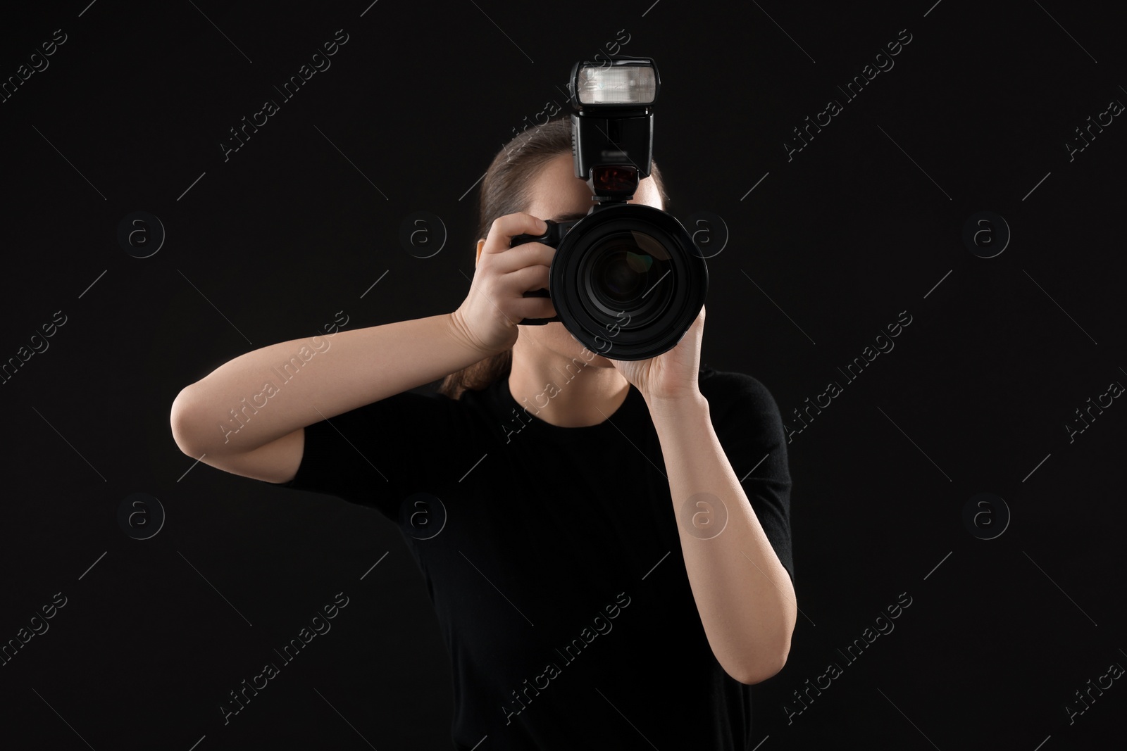 Photo of Professional photographer taking picture on black background