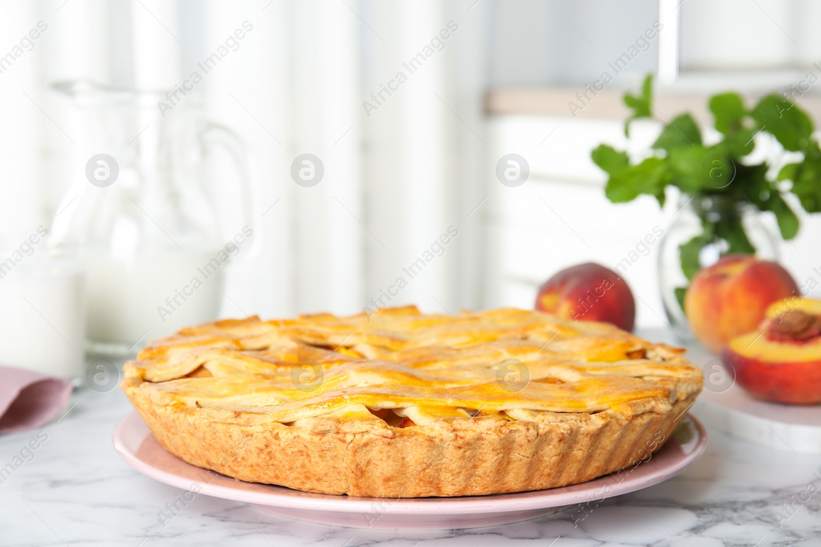 Photo of Delicious peach pie and fresh fruits on white marble table