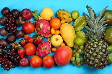 Assortment of fresh exotic fruits on light blue background, flat lay