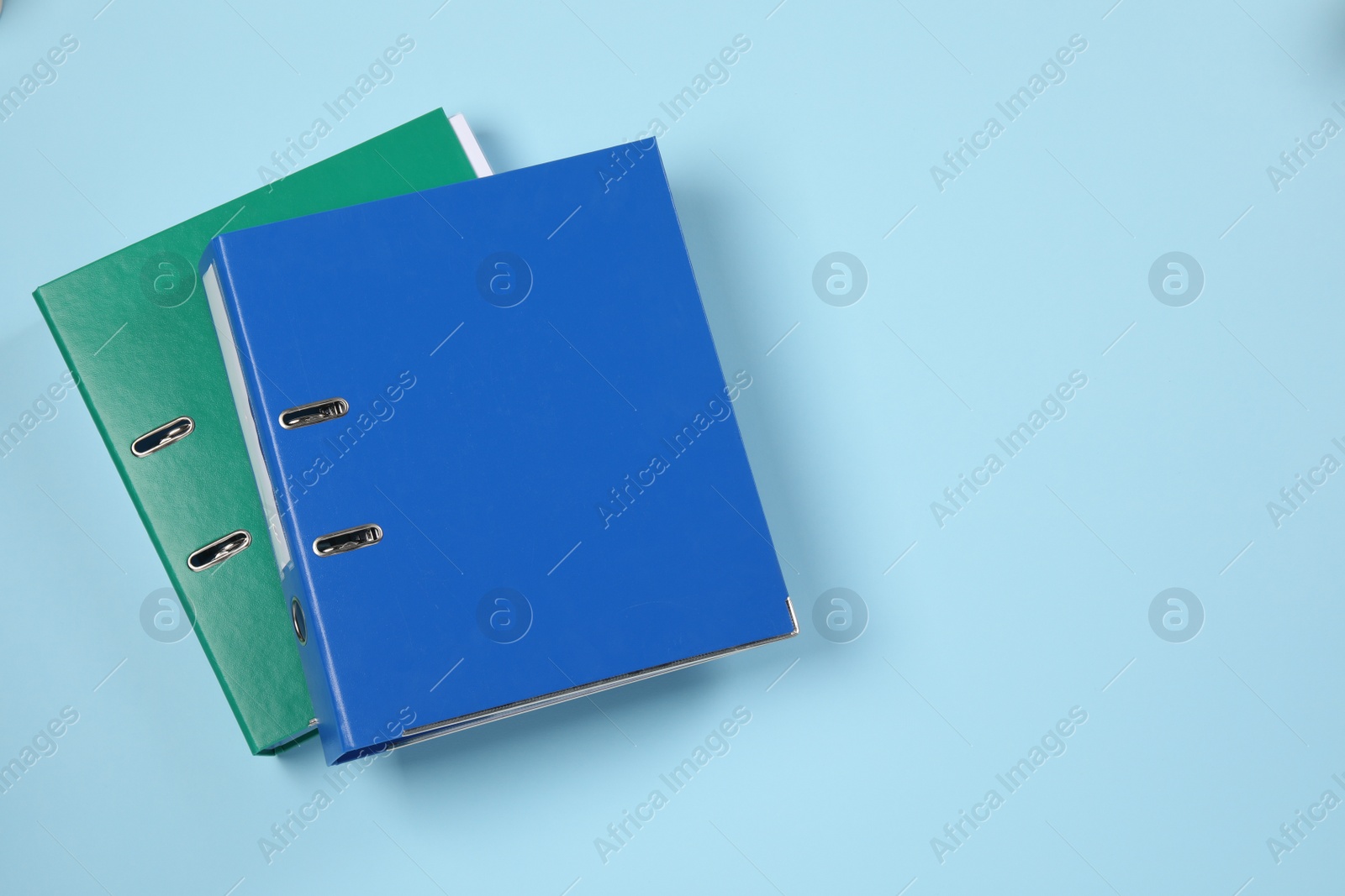 Photo of Office folders on light blue background, flat lay. Space for text