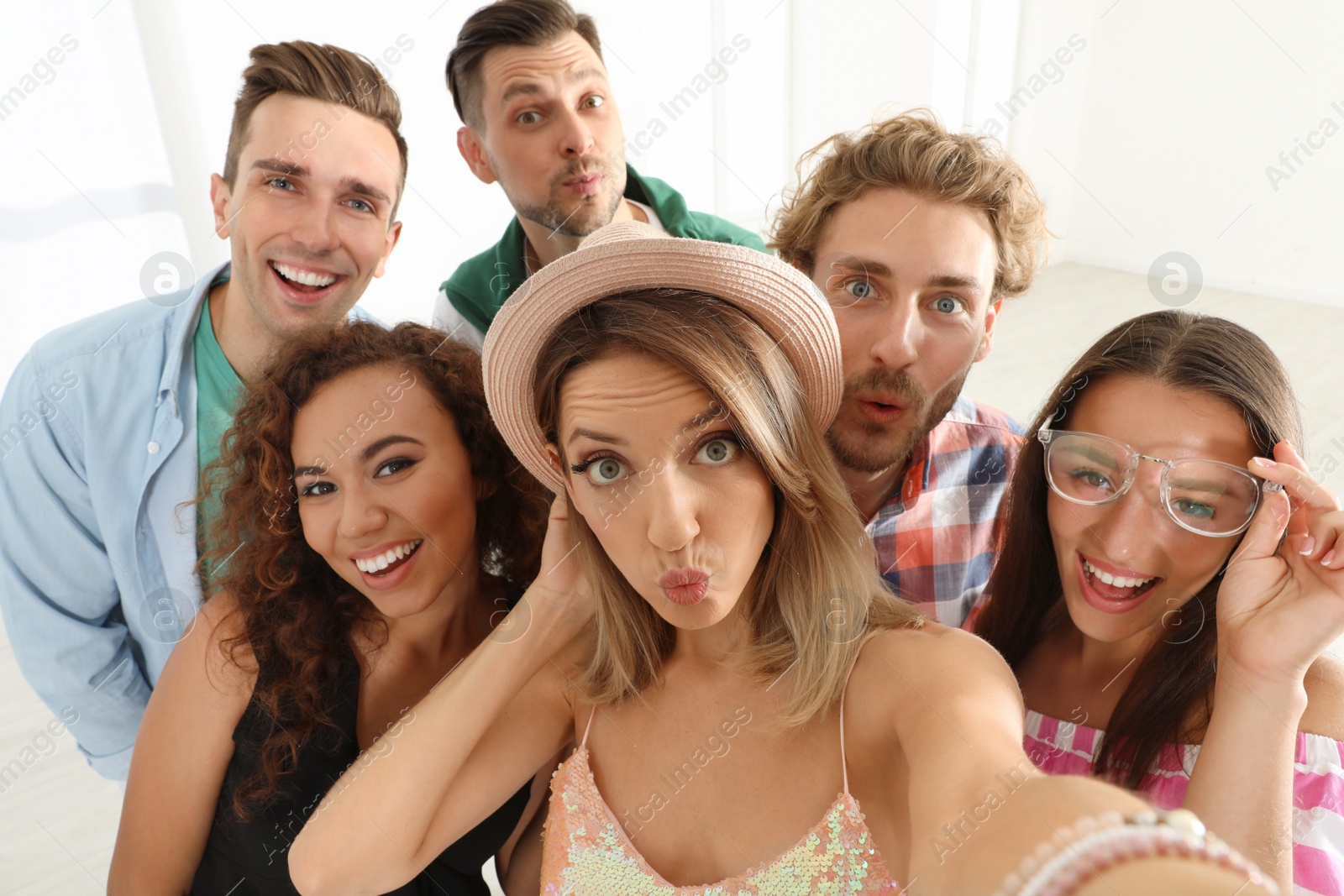 Photo of Group of happy young people taking selfie indoors