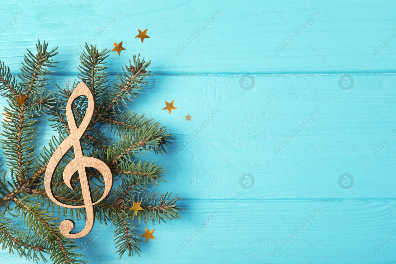 Photo of Composition with decorative treble clef and space for text on wooden background, top view. Christmas music concept