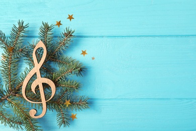 Composition with decorative treble clef and space for text on wooden background, top view. Christmas music concept