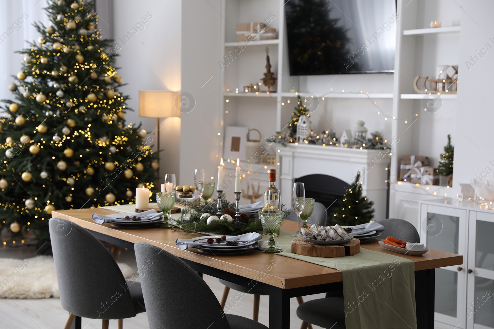 Photo of Christmas table setting with festive decor and dishware in living room