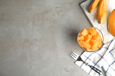 Flat lay composition with ripe cantaloupe melon on grey table. Space for text