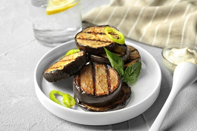 Plate with fried eggplant slices on table