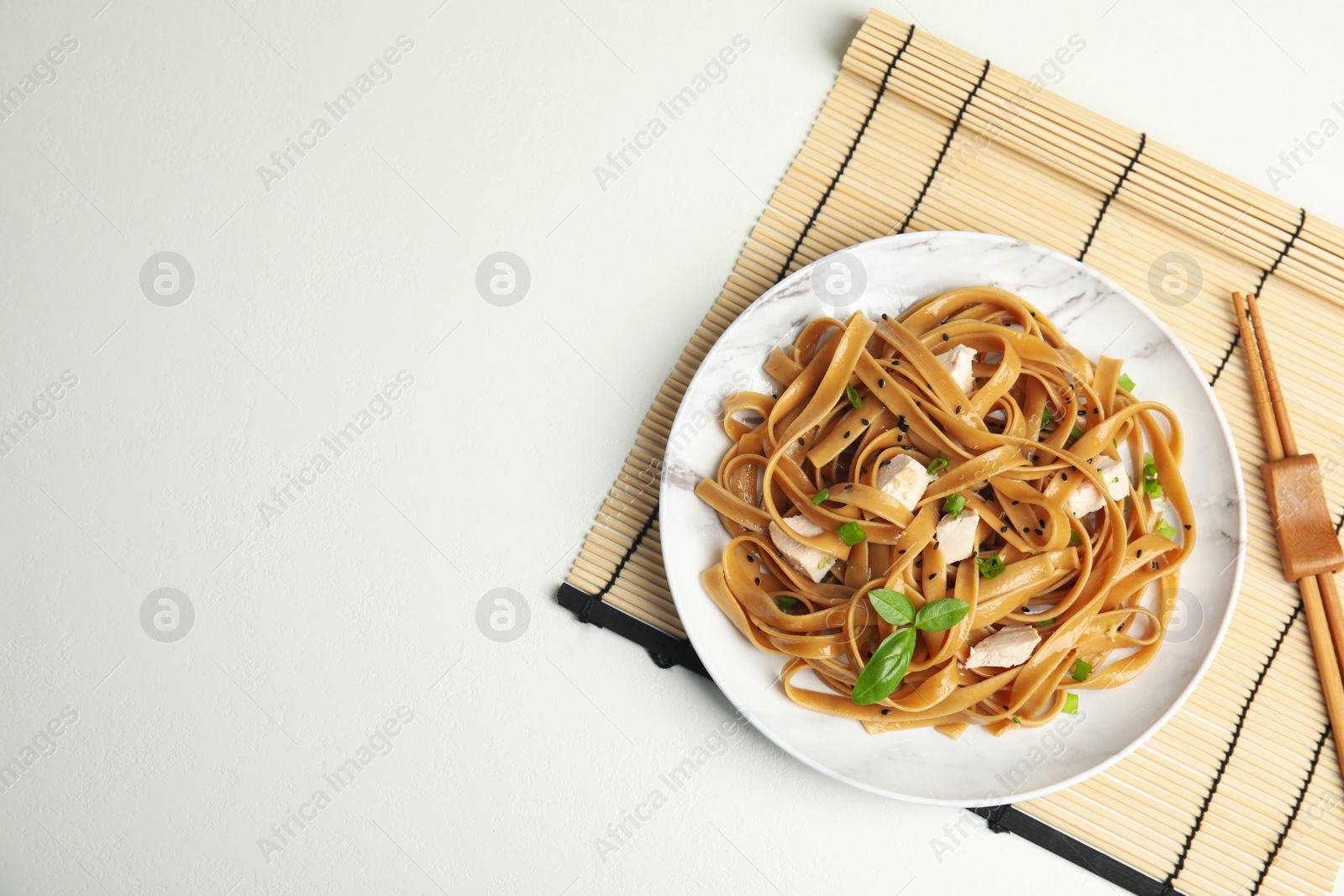 Photo of Tasty buckwheat noodles with meat served on white table, flat lay. Space for text