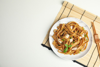 Tasty buckwheat noodles with meat served on white table, flat lay. Space for text