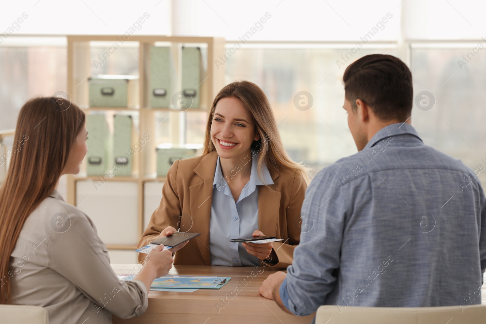 Photo of Travel agent giving tickets and passports to clients in office