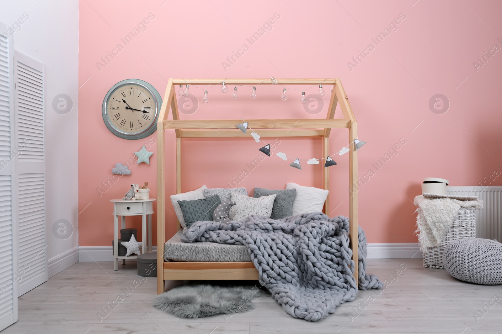 Photo of Child's room interior with comfortable bed and garland