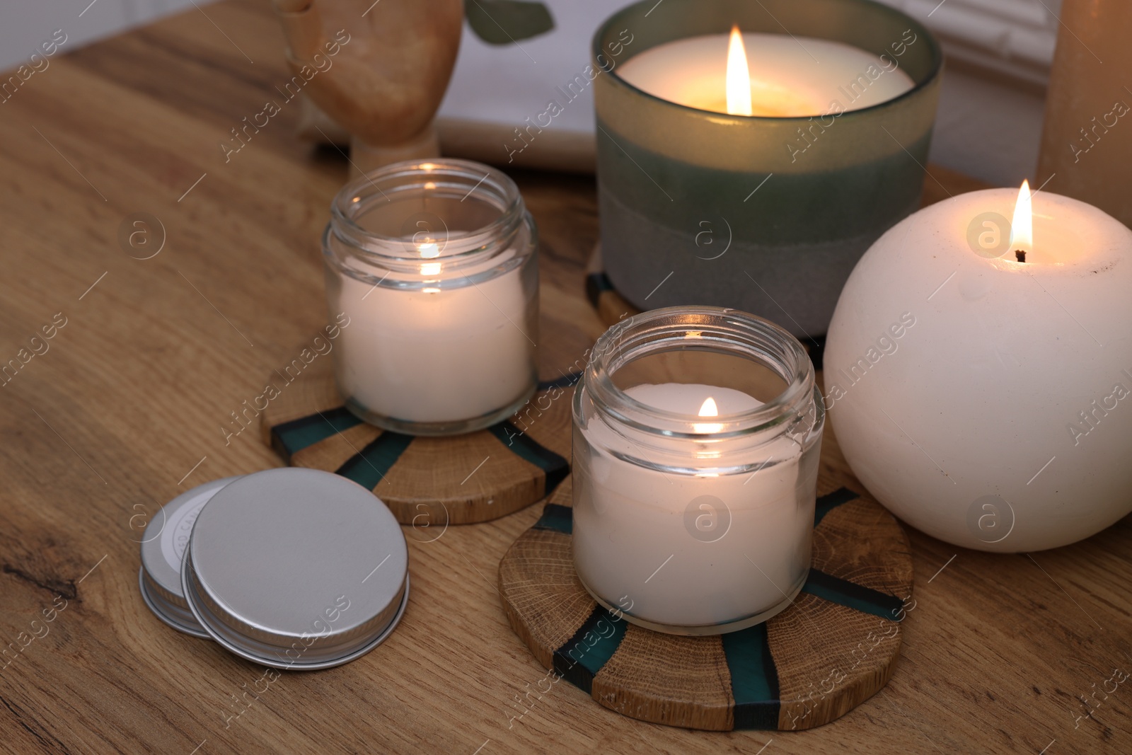 Photo of Many different burning candles on wooden table