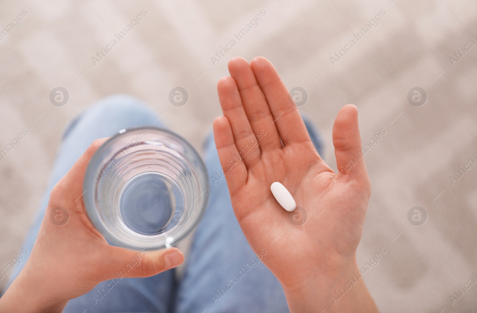 Photo of Young woman with abortion pill and glass of water, top view