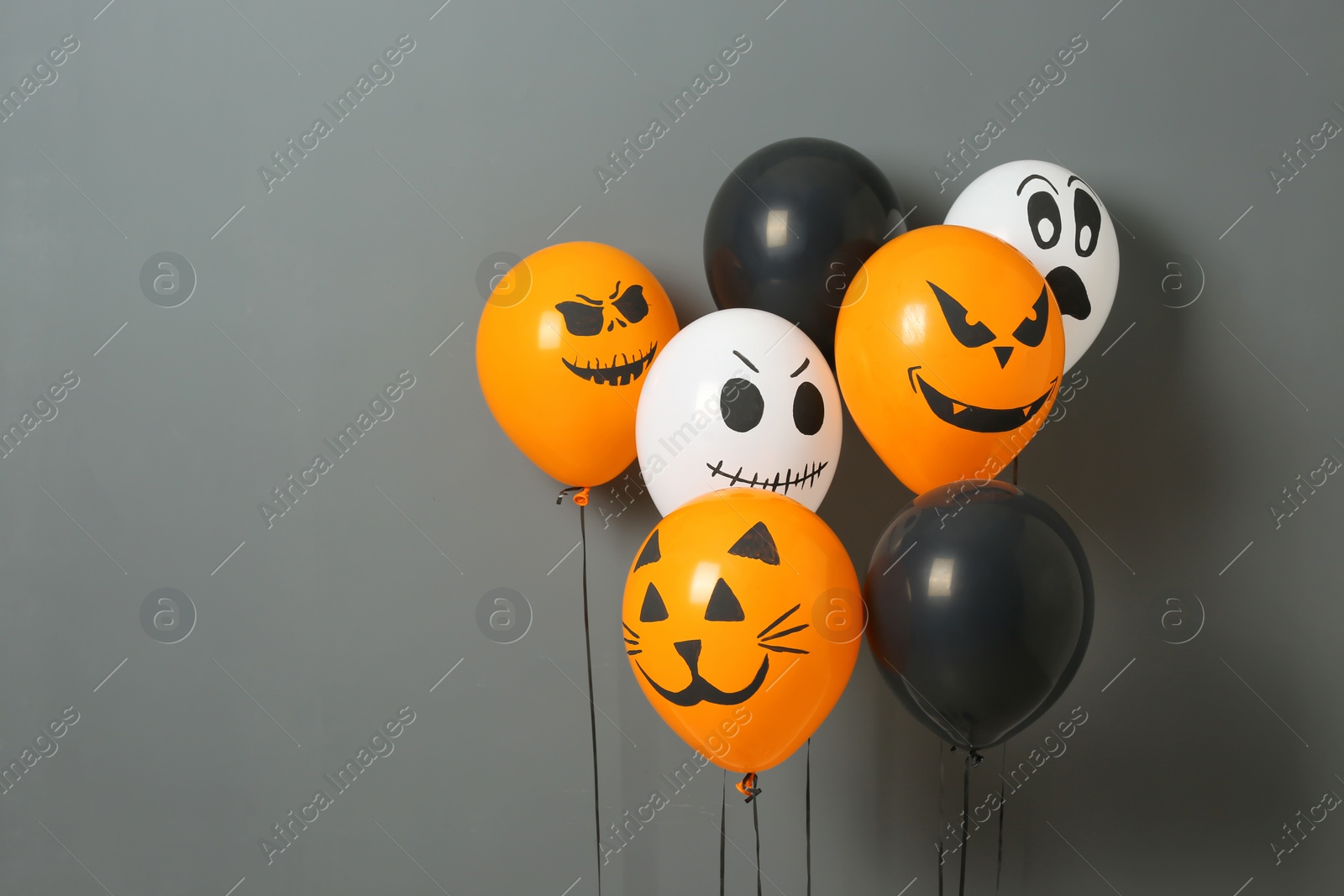 Photo of Color balloons for Halloween party on gray background. Space for text