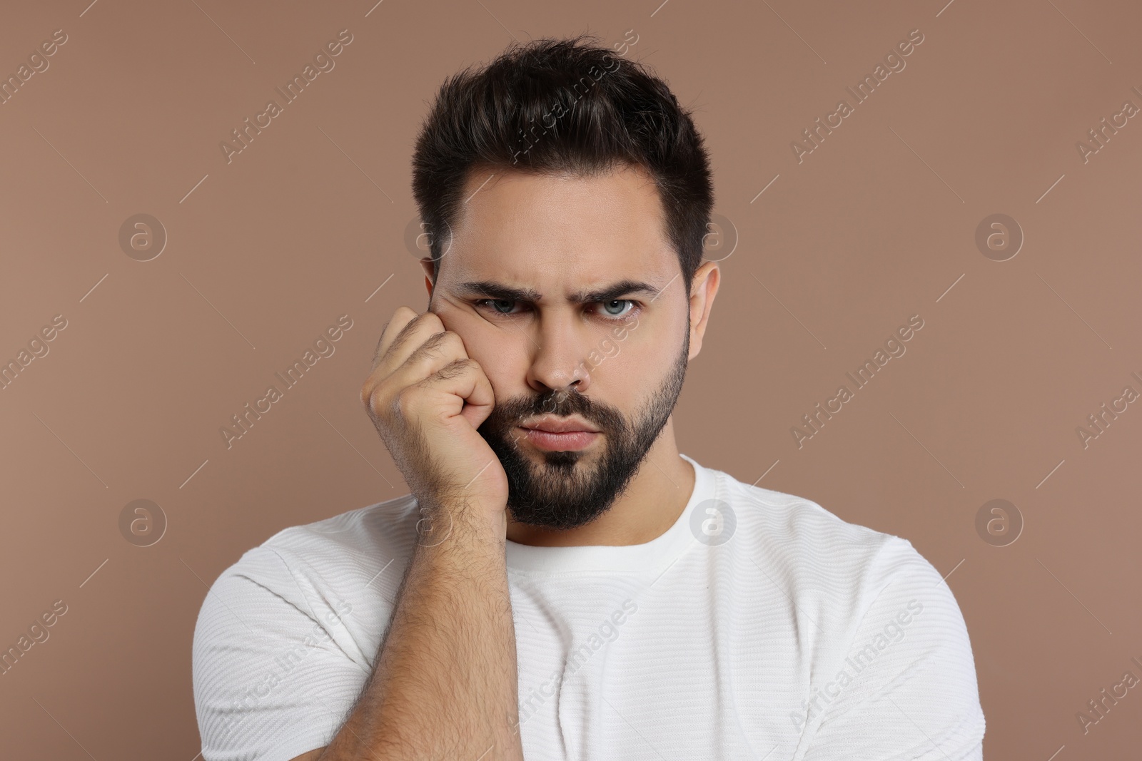 Photo of Portrait of resentful man on brown background