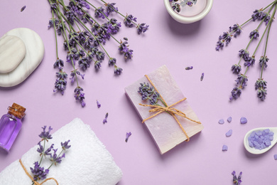 Photo of Cosmetic products and lavender flowers on lilac background, flat lay