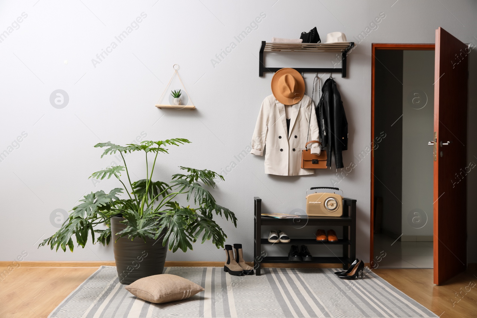 Photo of Hallway interior with stylish furniture, clothes and accessories