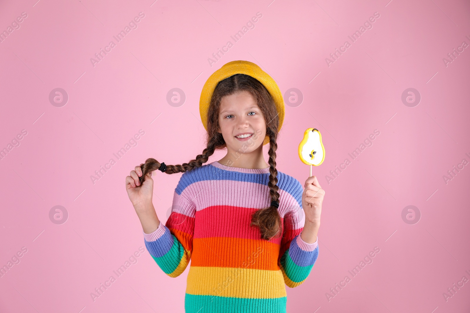 Photo of Little girl with candy on color background