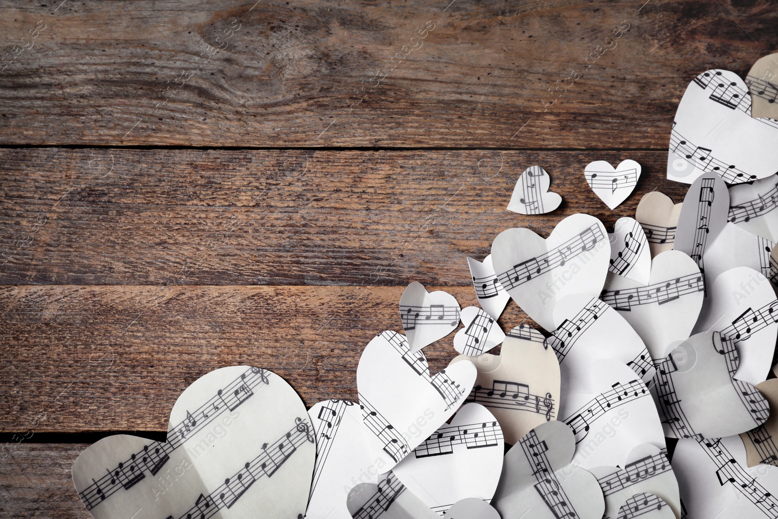 Photo of Paper hearts with music notes and space for text on wooden background, flat lay