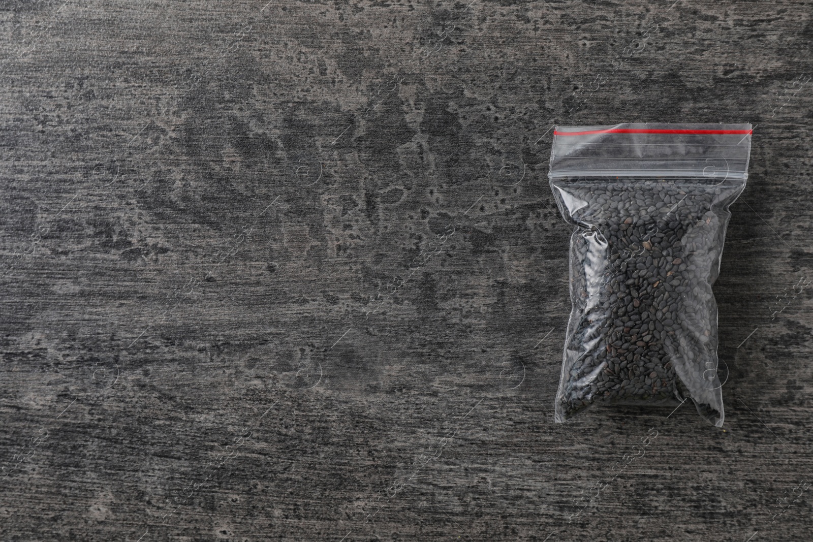 Photo of Plastic bag with spice on grey background, top view