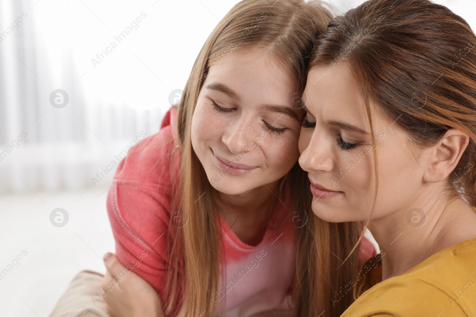 Photo of Happy mother hugging her teenager daughter at home