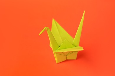 Photo of Origami art. Handmade paper crane on orange background