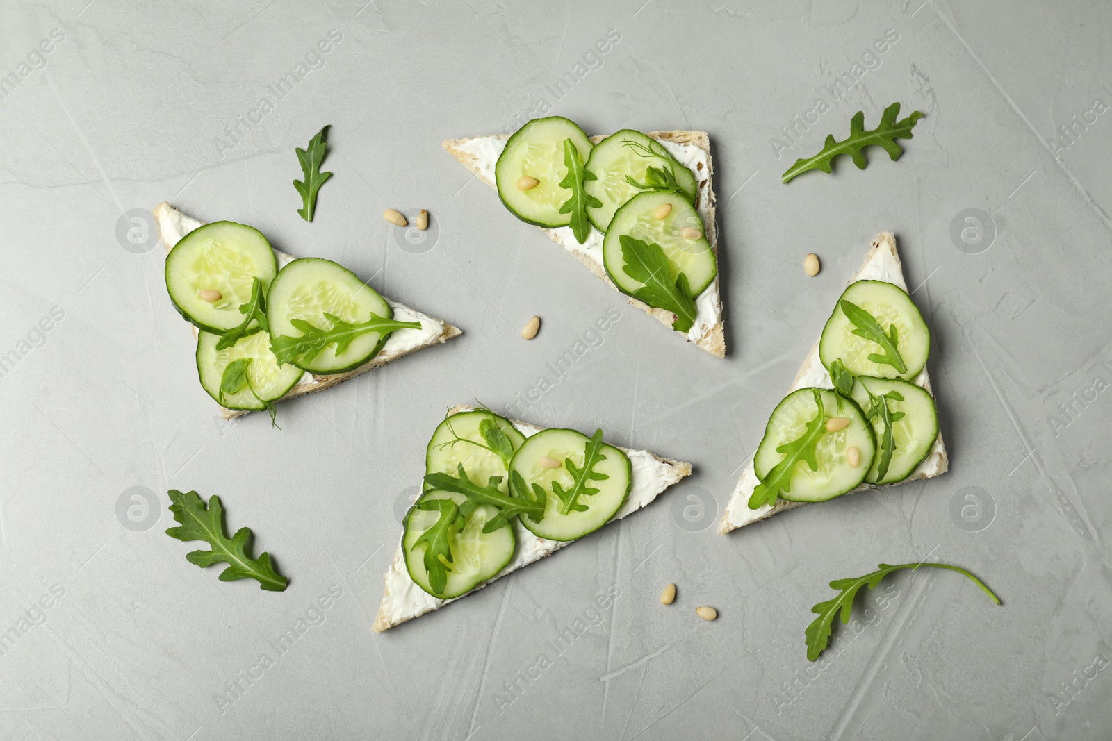 Photo of Flat lay composition with traditional English cucumber sandwiches on grey background