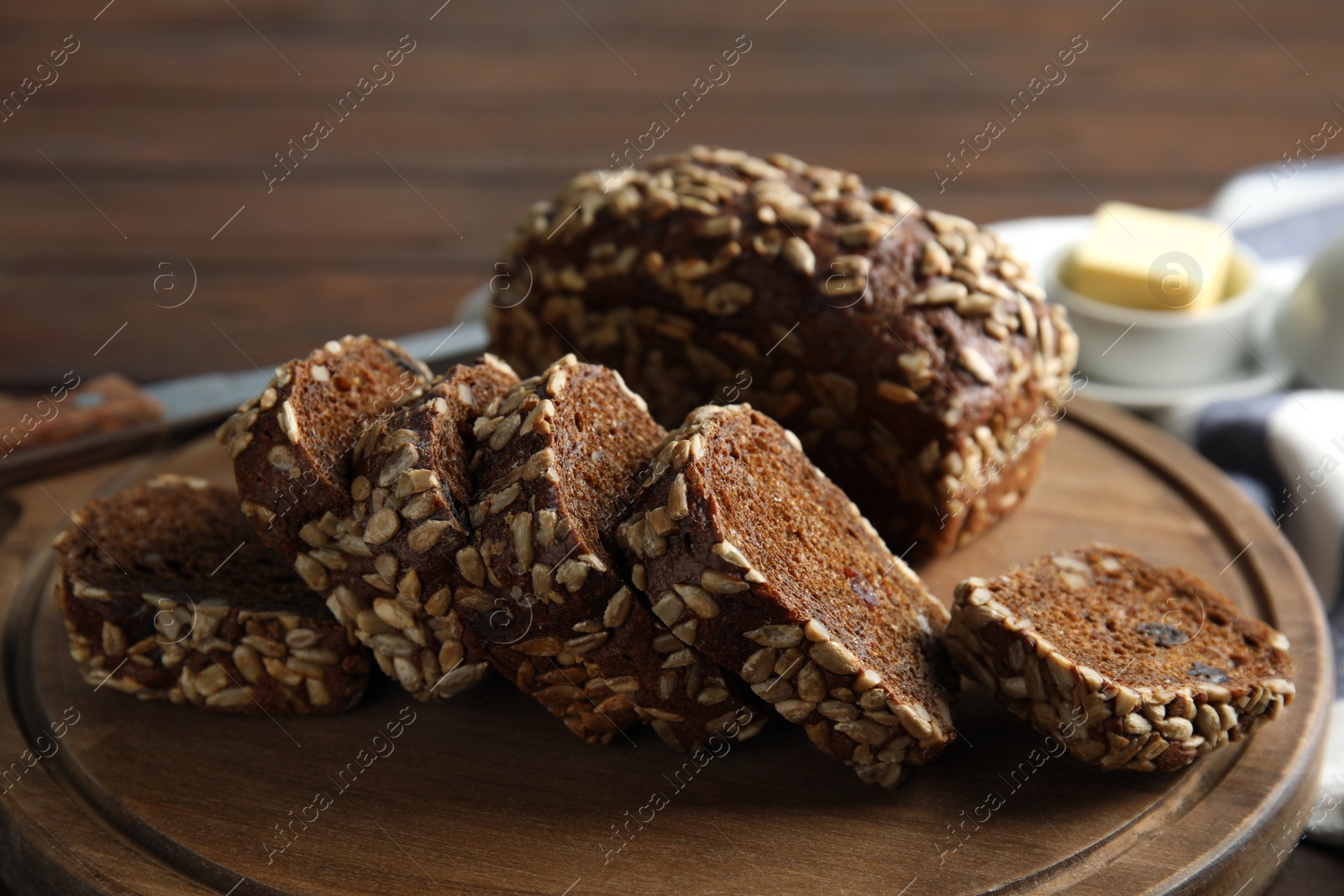 Photo of Board with tasty rye bread on table, closeup