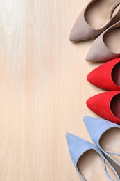 Photo of Flat lay composition of stylish lady's shoes on wooden background, space for text