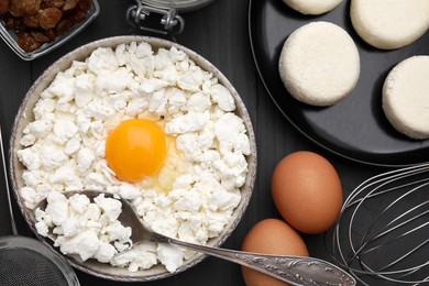 Uncooked cottage cheese pancakes and different ingredients on grey wooden table, flat lay