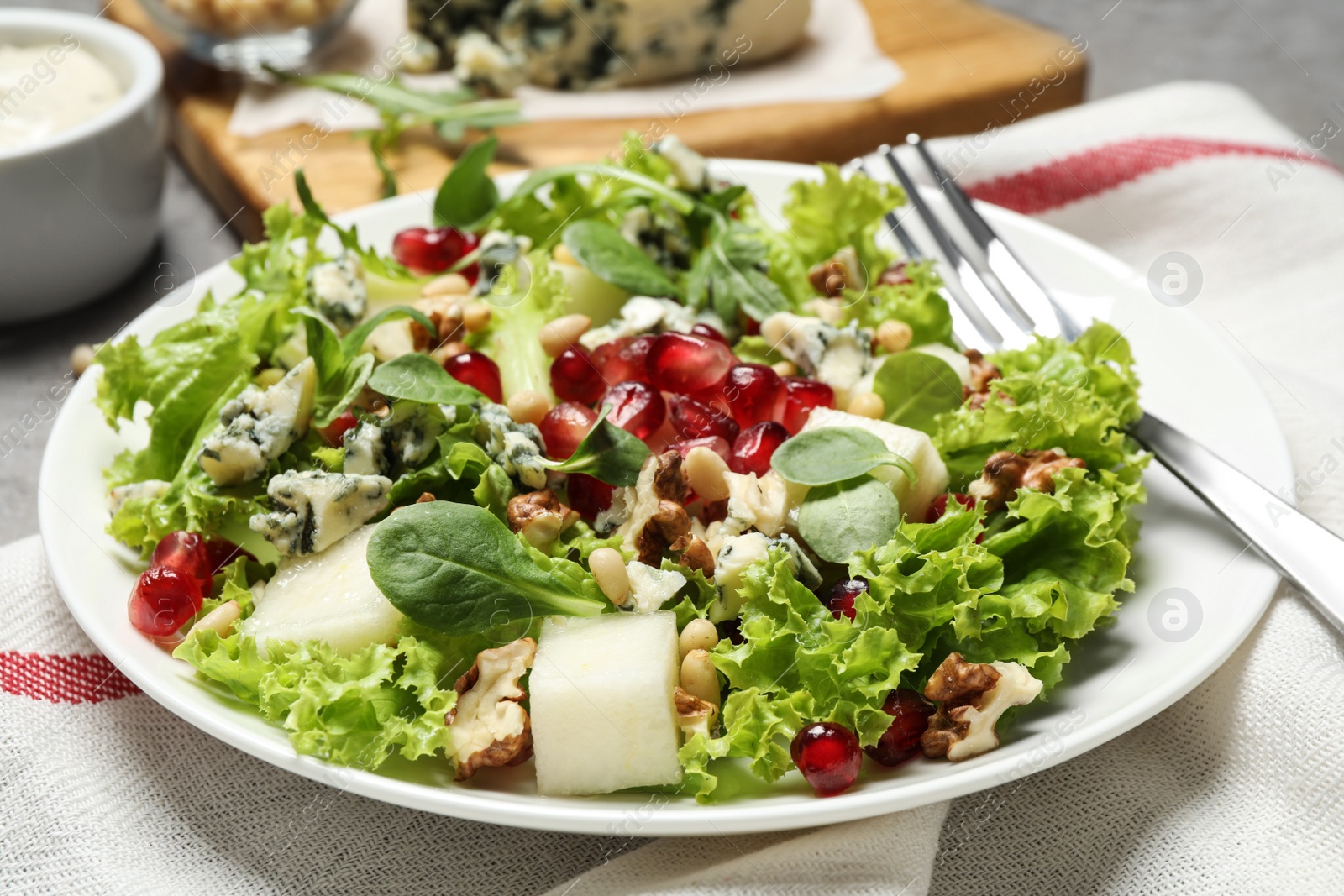 Photo of Fresh salad with pear on table, closeup