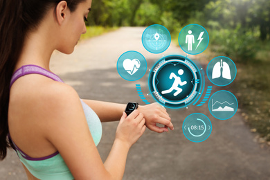 Woman using smart watch during training outdoors. Icons near hand with device