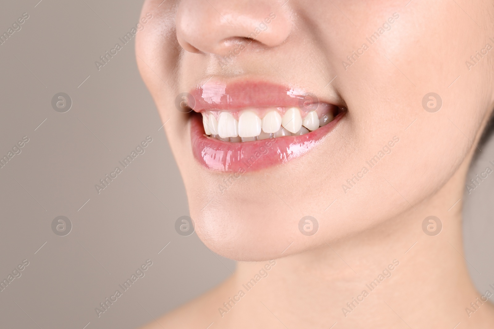 Photo of Beautiful young woman with healthy teeth on color background, closeup