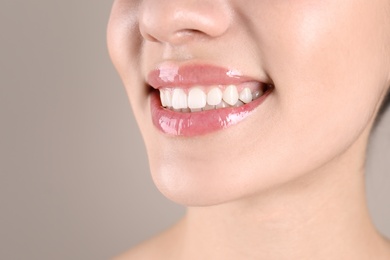 Photo of Beautiful young woman with healthy teeth on color background, closeup