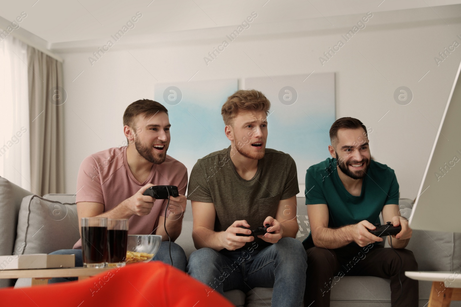 Photo of Emotional friends playing video games at home