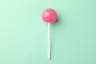 Tasty lollipop on turquoise background, top view