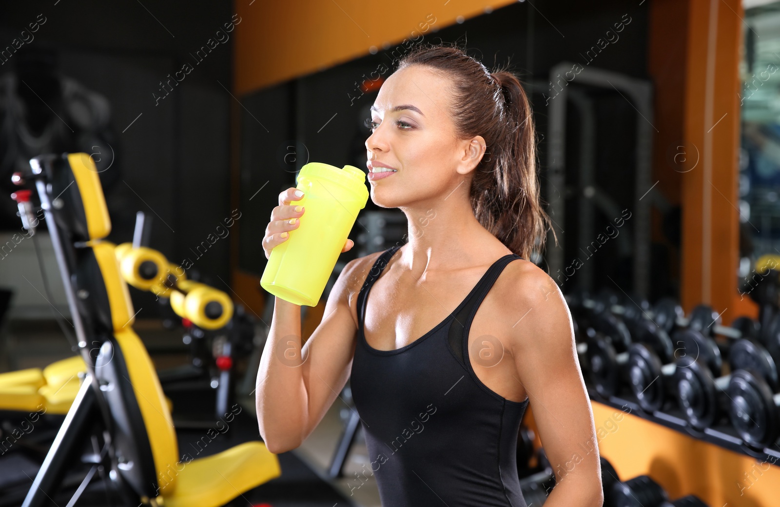 Photo of Portrait of athletic woman with protein shake in gym