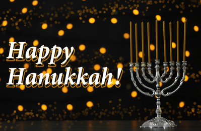 Silver menorah on black table. Happy Hanukkah!