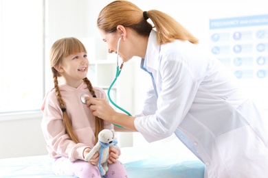 Photo of Children's doctor examining little girl in hospital