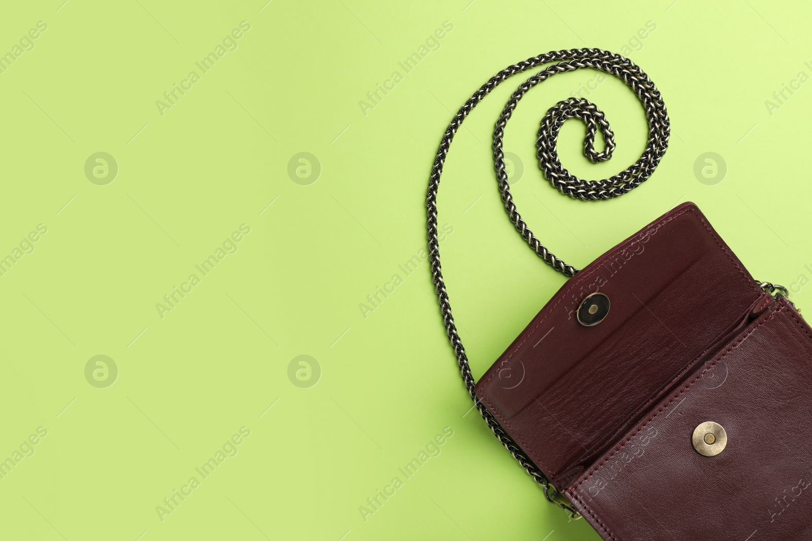 Photo of Stylish women's bag on green background, top view. Space for text