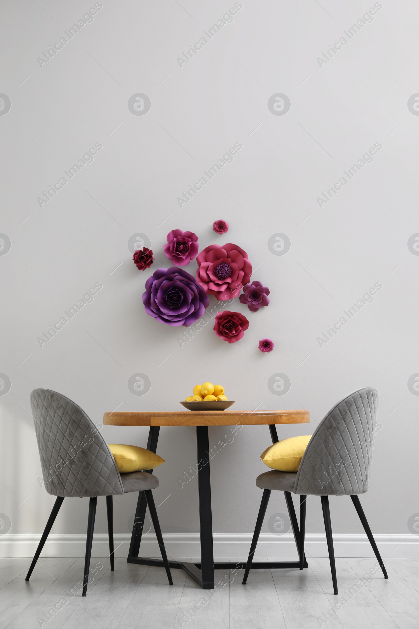 Photo of Dining table and chairs near wall with floral decor