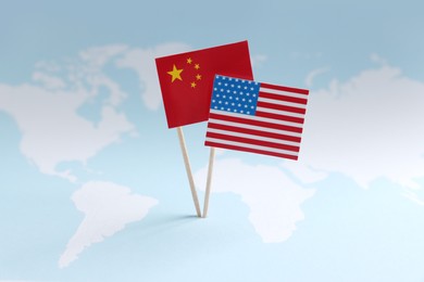 Photo of American and Chinese flags on world map. Trade war concept
