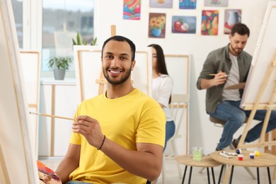 Photo of Group of students attending painting class in studio. Creative hobby