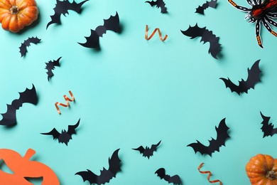 Frame made with Halloween decor elements on light blue background, flat lay. Space for text