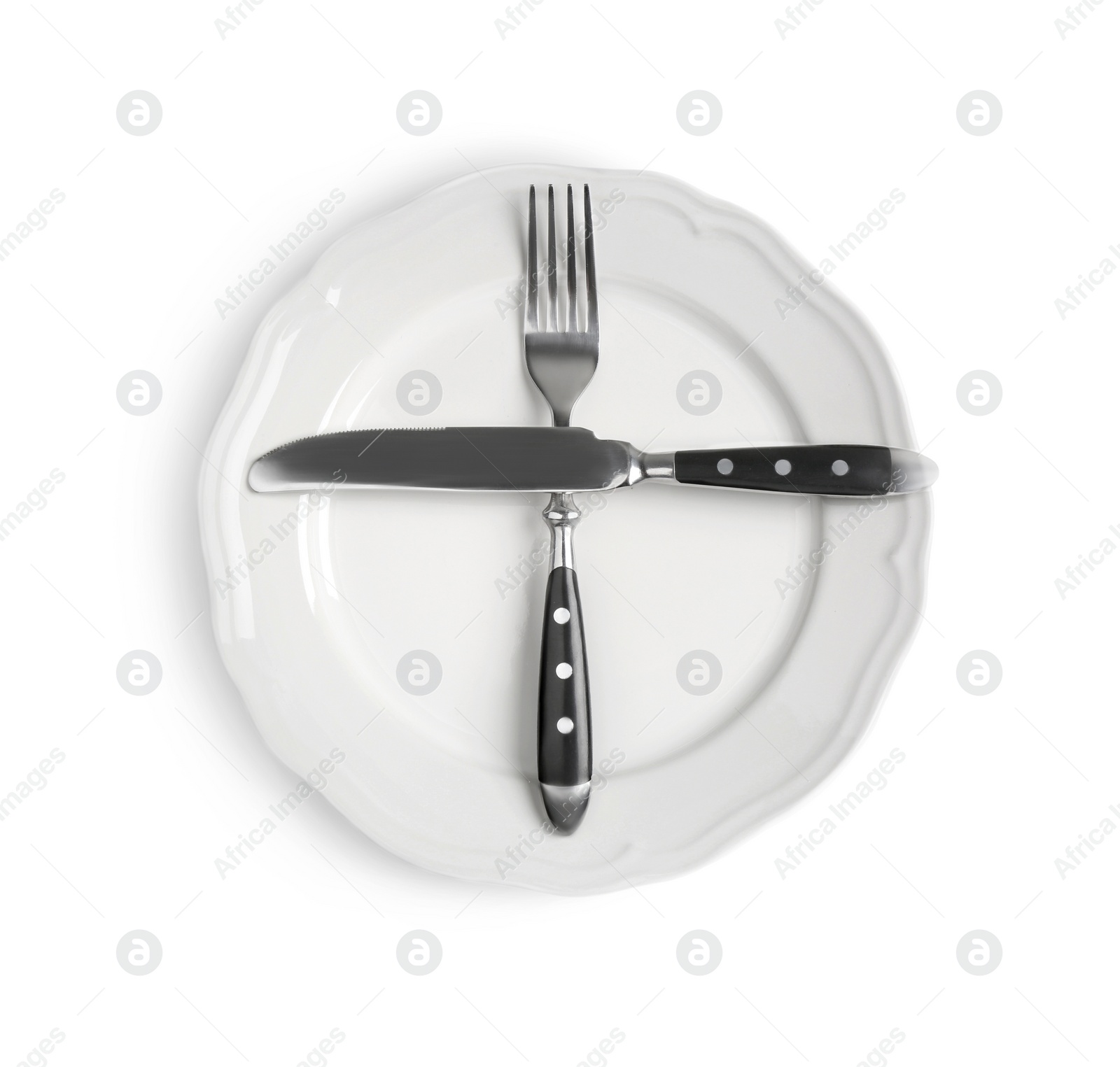 Photo of Ceramic plate, fork and knife on white table, top view