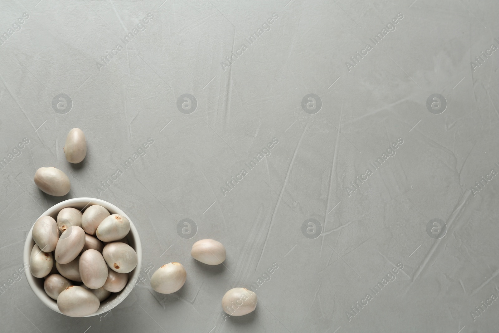 Photo of Fresh raw jackfruit seeds on grey table, flat lay. Space for text