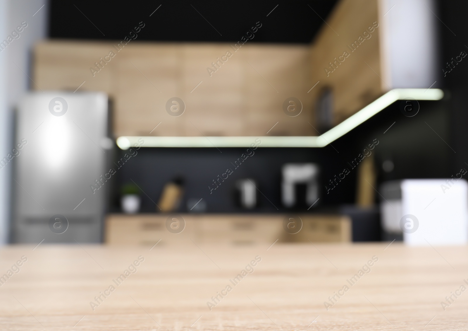 Photo of Countertop and blurred view of cozy modern kitchen interior on background